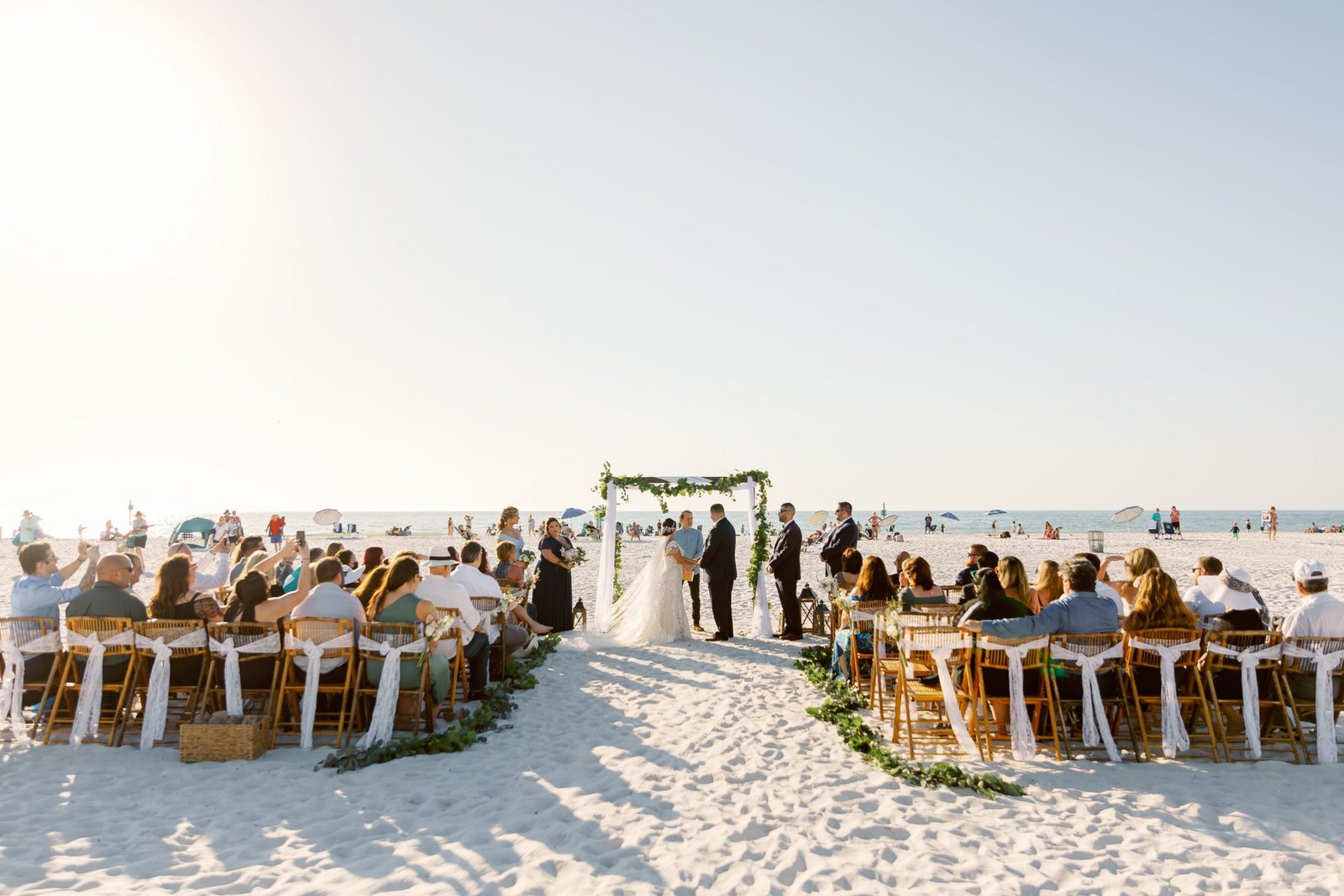 A real beach wedding ceremony on the white sand at Clearwater Beach, guests seated in rows facing the Gulf